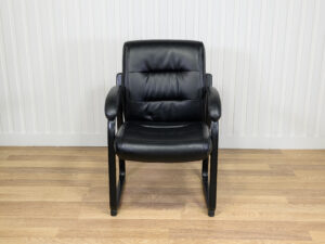 Chaise visiteur en similicuir noir avec structure en métal et des accoudoirs intégrés.